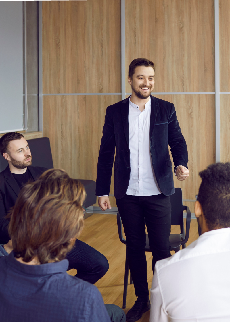 A gentleman stood up in front of a small group of people, mid-workshop.