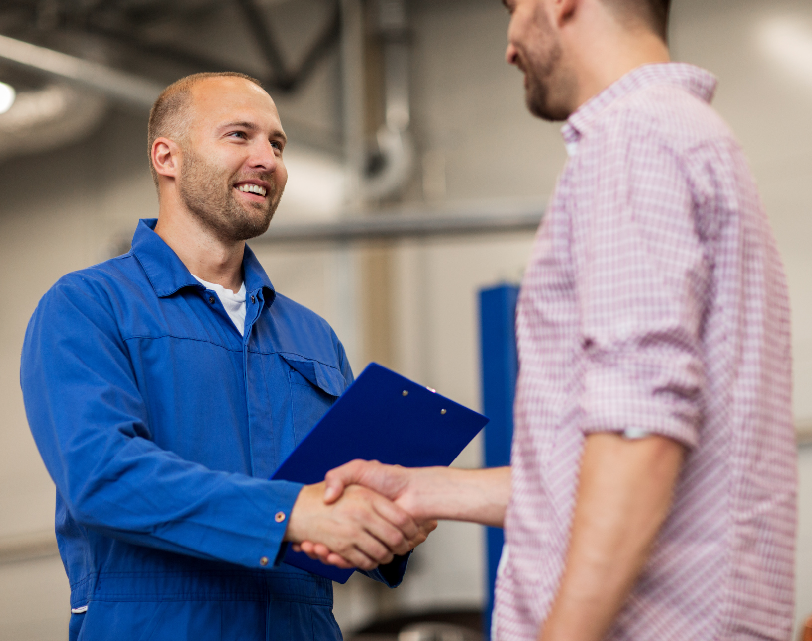 A field service tech shaking hands with a satisfied customer.